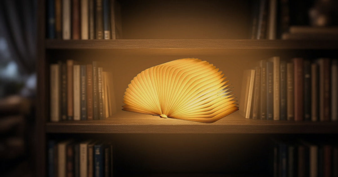 Folding book lamp opened into a glowing fan of paper pages on a bookshelf at night